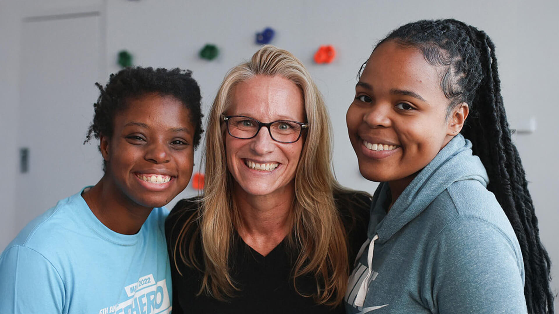 Three team members smile together